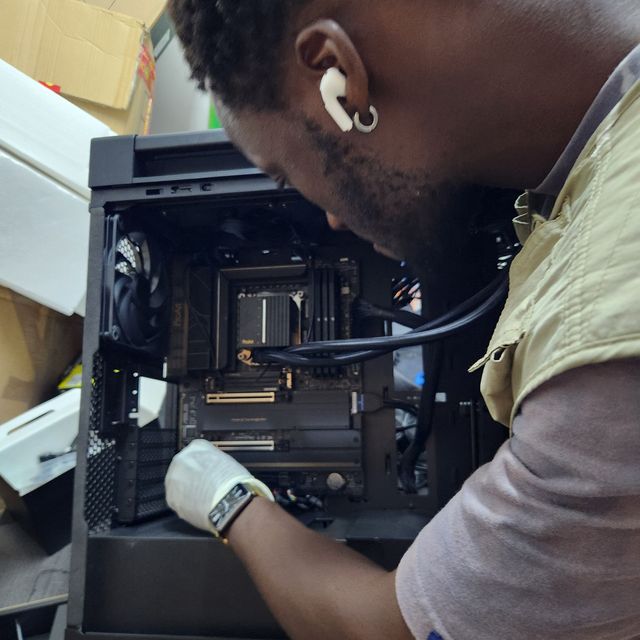 Technicien Génie-iTech assemblant une configuration PC haut de gamme en atelier